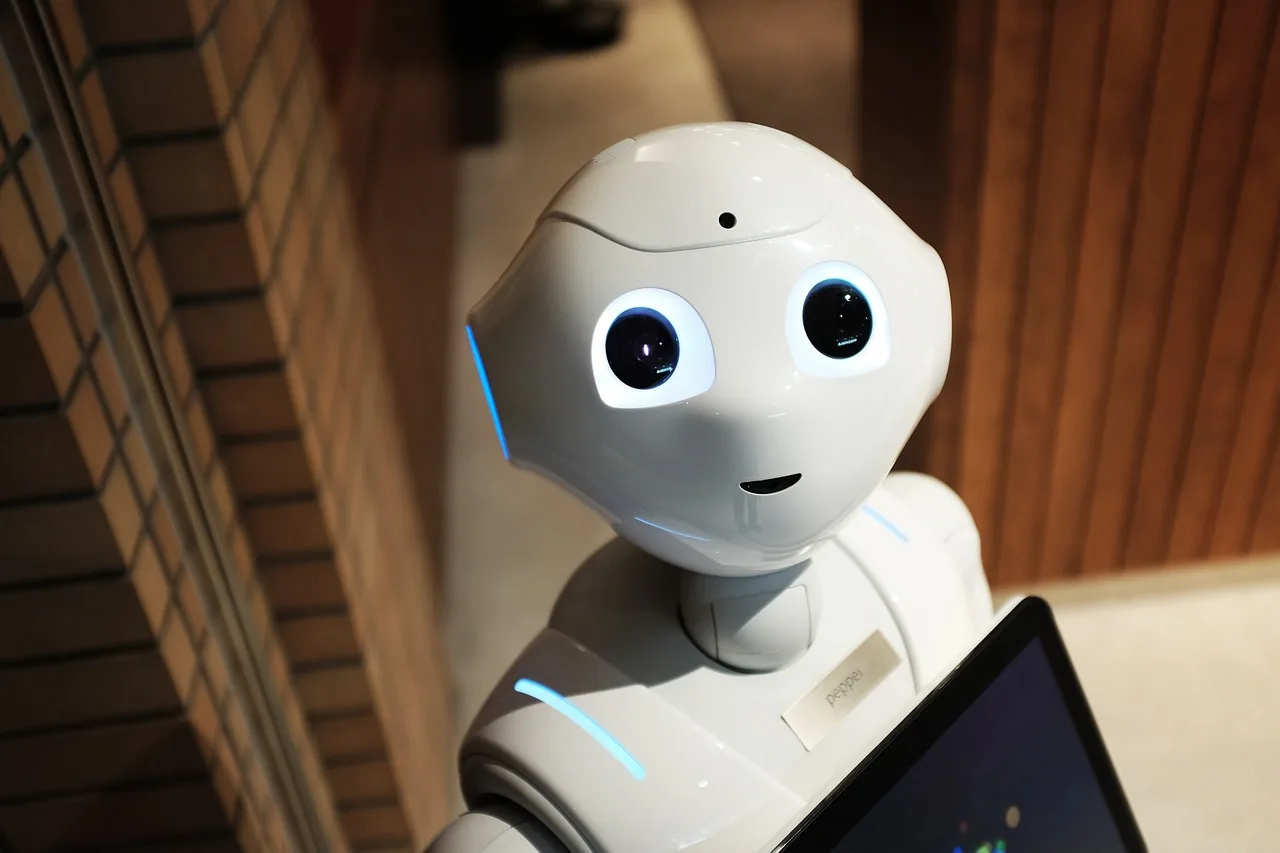 White robot holding a tablet in a café